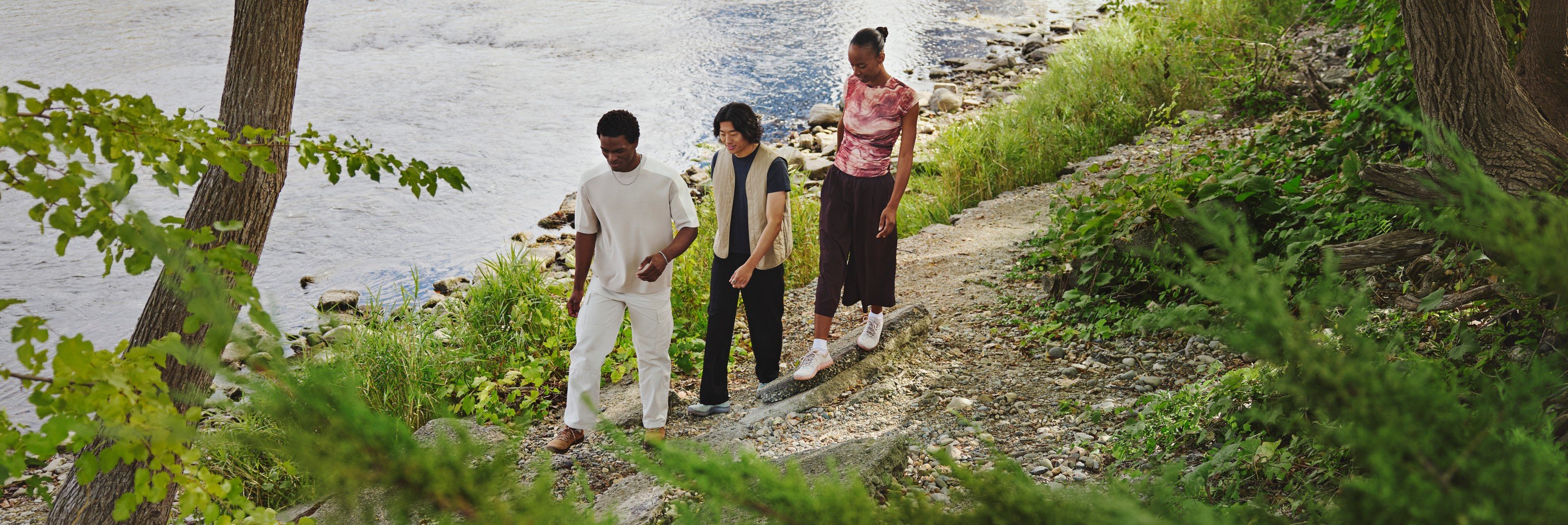 Three friends walking a riverside trail in Merrell barefoot shoes